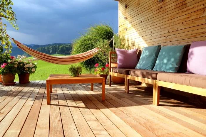 Holzterrasse mit Gartenmöbeln und Hängematte